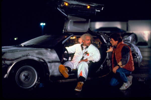 Christopher Lloyd, left, as Dr. Emmett Brown, and Michael J. Fox as Marty McFly with the DeLorean time machine from the 1985 film “Back to the Future.”